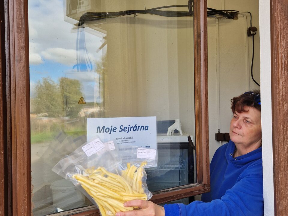 Monika Kuklišová podává balení sejrovek výdejním okénkem sýrárny